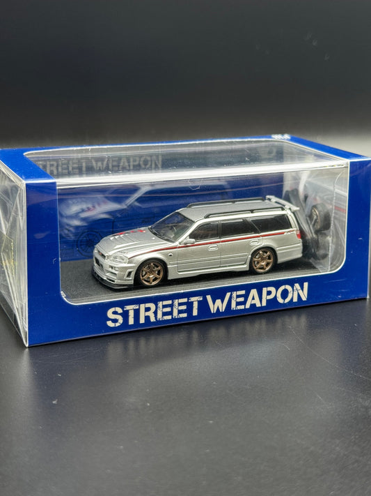 Nissan Stagea R34 Argent / Bande Rouge – Street Weapon 1/64 | 107/499 SVRdiecast