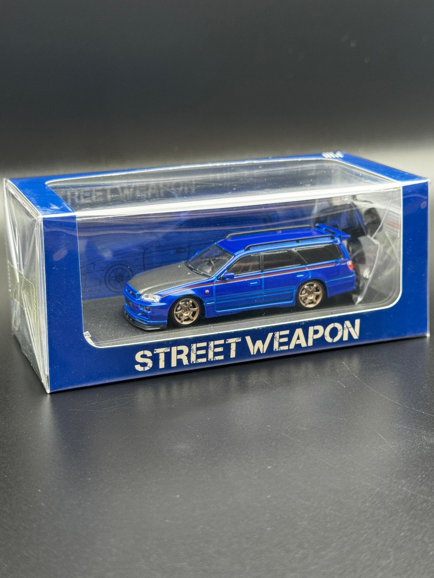 Nissan Stagea GT-R R34 Bleu / Capot Carbone / Bande Rouge – Street Weapon 1/64 | 195/499 SVRdiecast