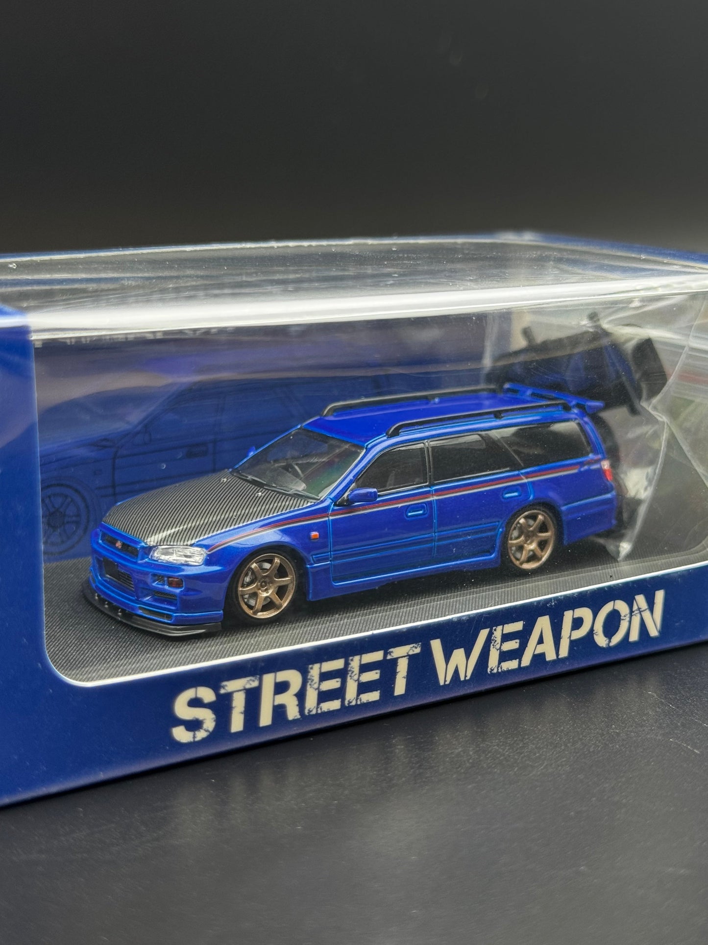 Nissan Stagea GT-R R34 Bleu / Capot Carbone / Bande Rouge – Street Weapon 1/64 | 195/499 SVRdiecast